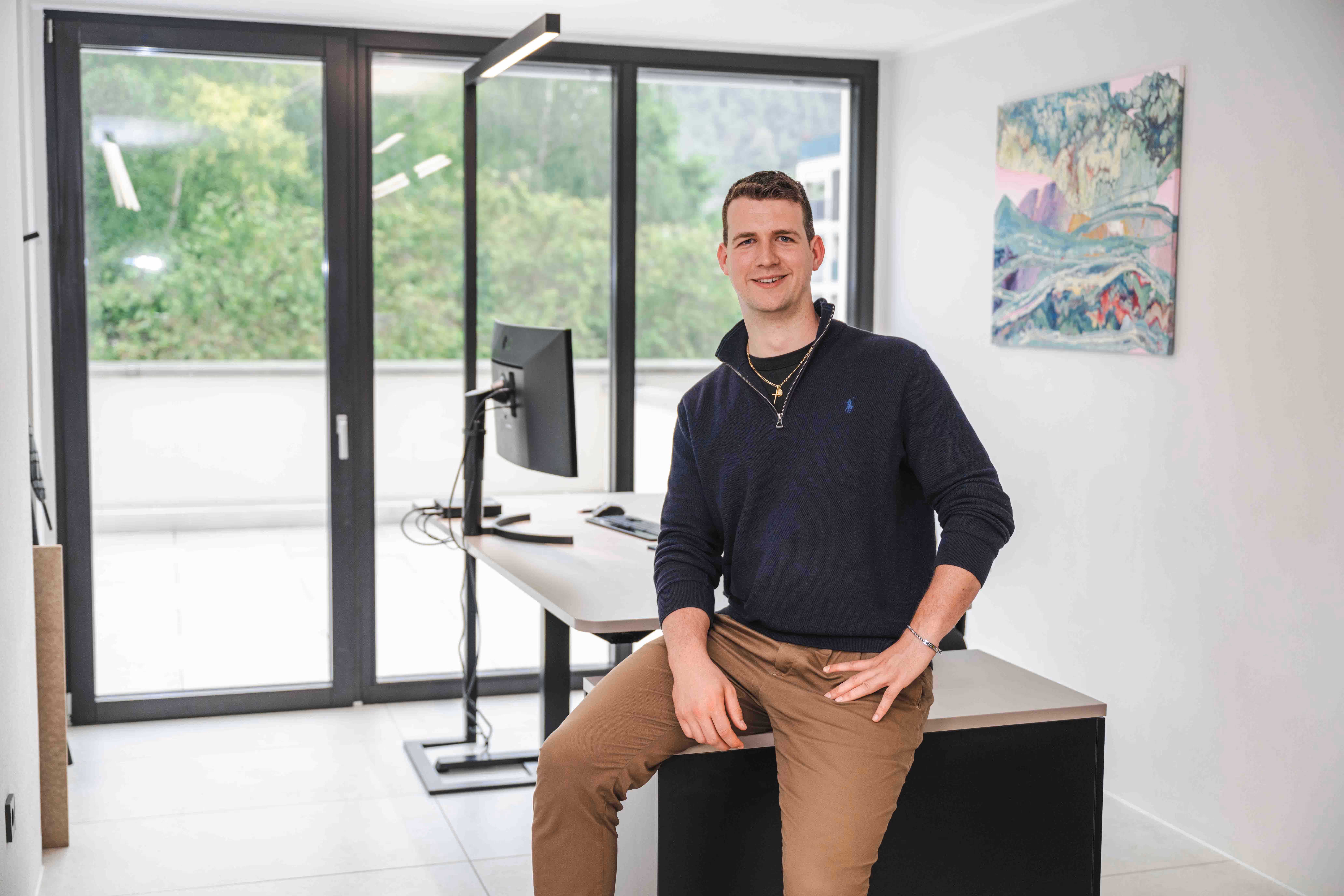 Verwalter von vewa lehnt an einem Schreibtisch im Büro
